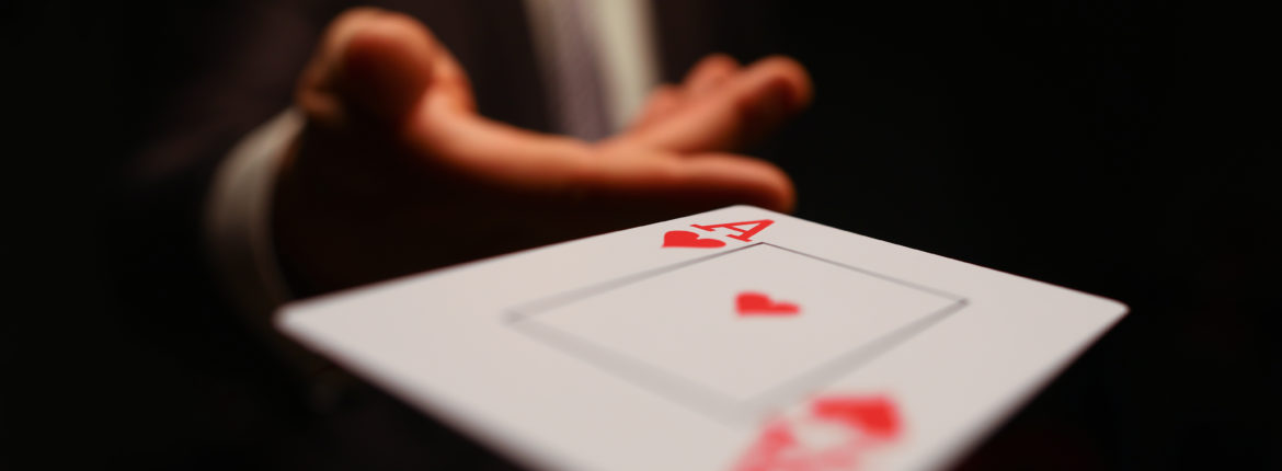 Businessman in suit throws his hand playing card ace of worms to opponent on a black background. Winning in business payout concept